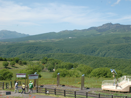 山に囲まれた嬬恋牧場の入り口の写真
